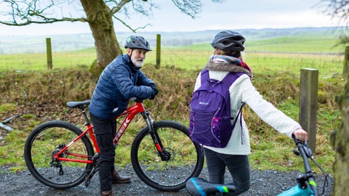 Two visitors with bikes on a trail around Wallington